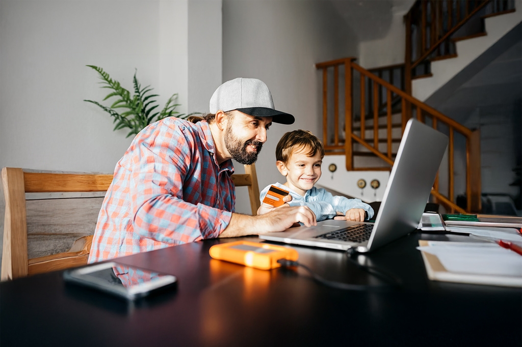 A father and son looking at a laptop