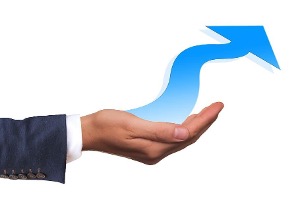 Hand holding an arrow pointing upwards